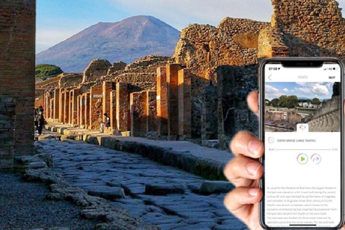 osoba držící mobilní telefon před ulicí