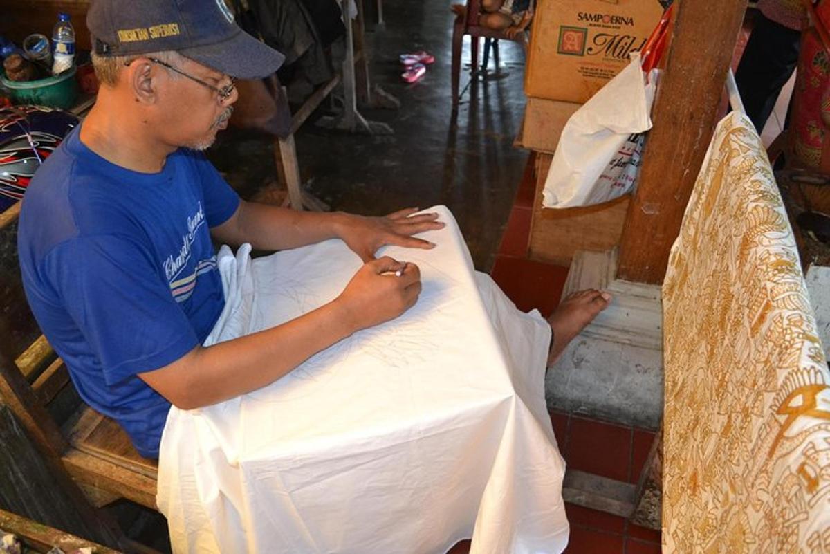 un home treballa sobre una taula amb un drap