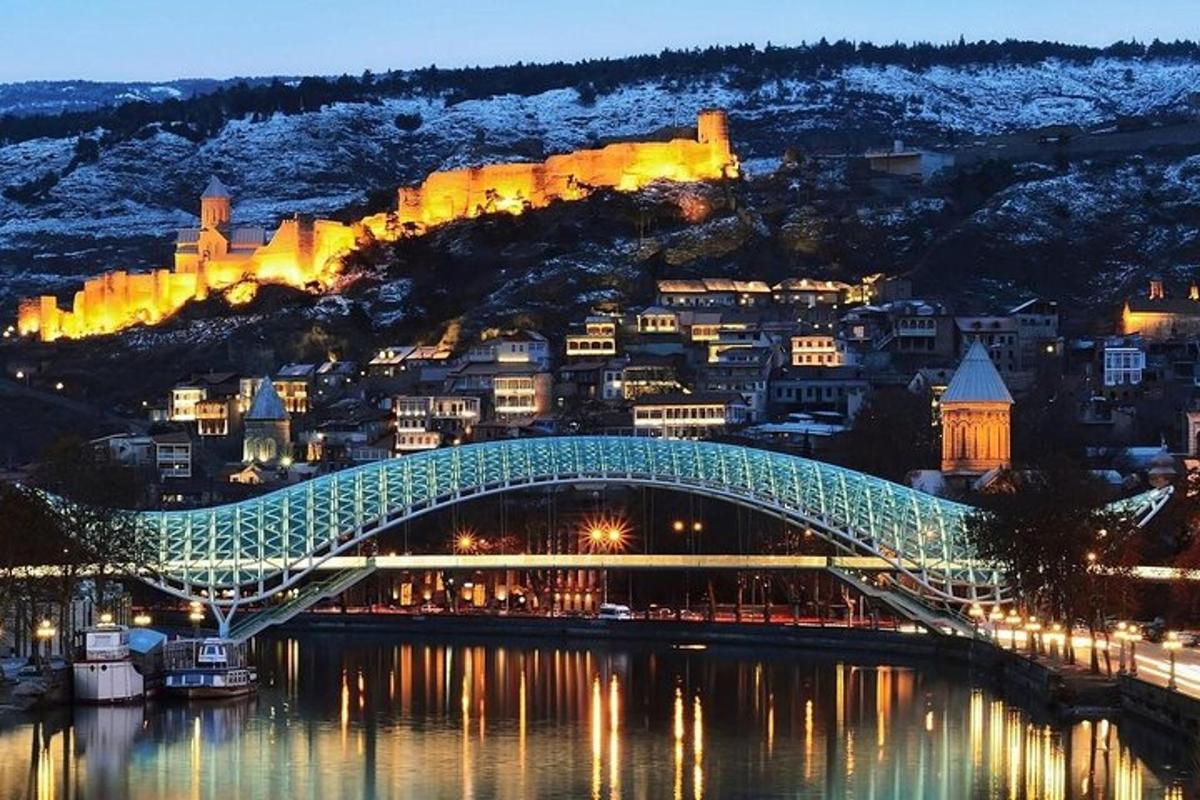 μια γέφυρα πάνω από ένα ποτάμι με μια πόλη στο βάθος