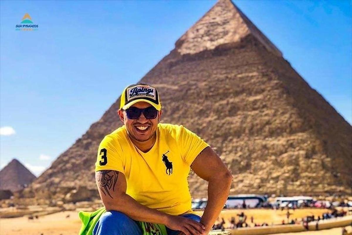 un uomo è seduto davanti alle piramidi