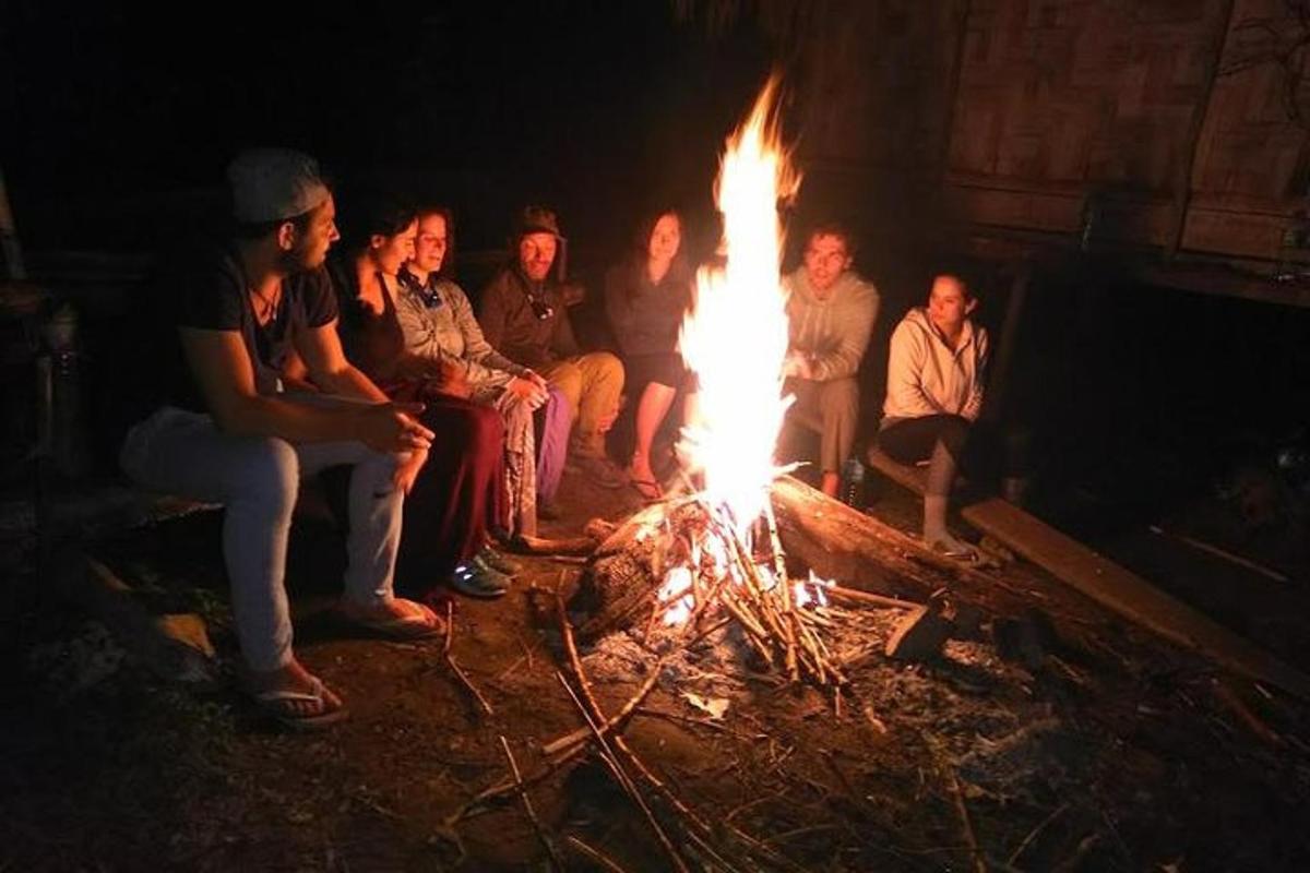 a group of people sitting around a fire
