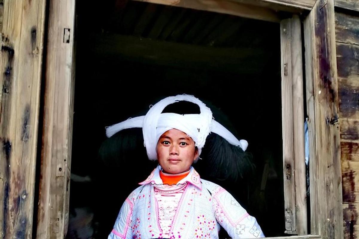 a woman dressed in a costume looking out of a window