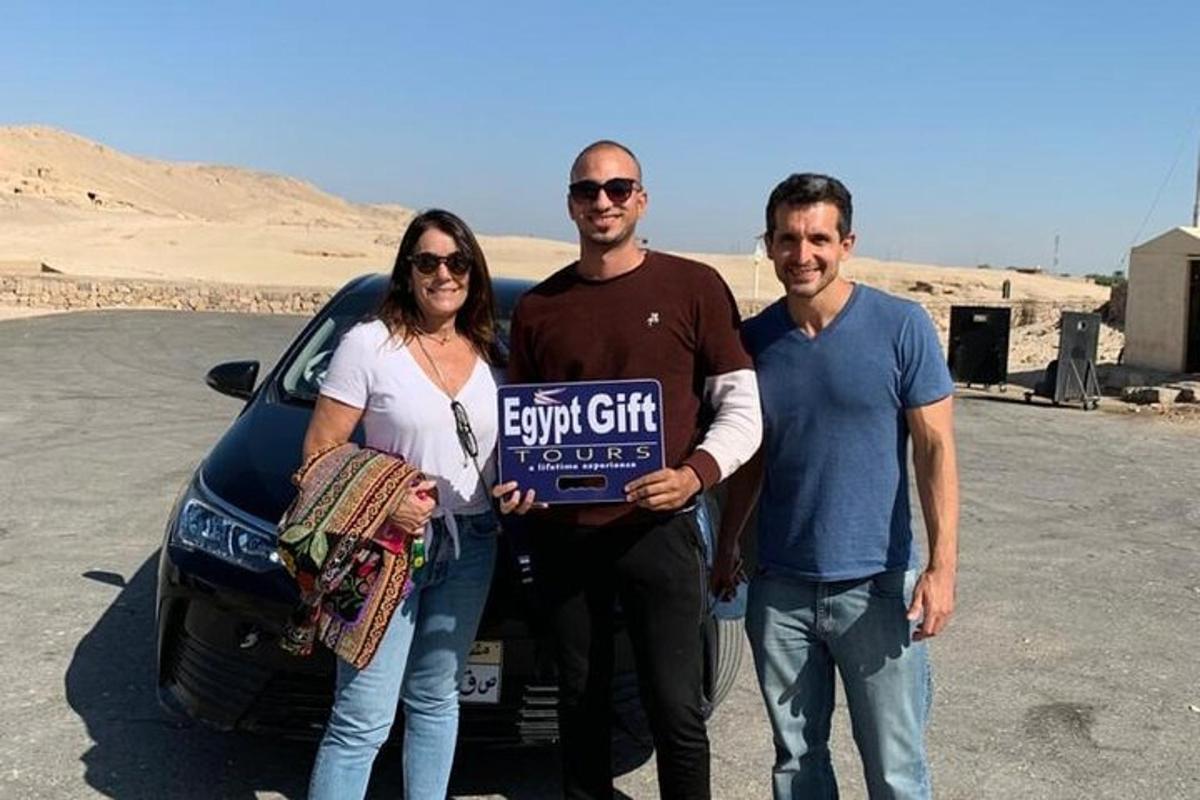 Un grupo de tres personas de pie junto a un coche.