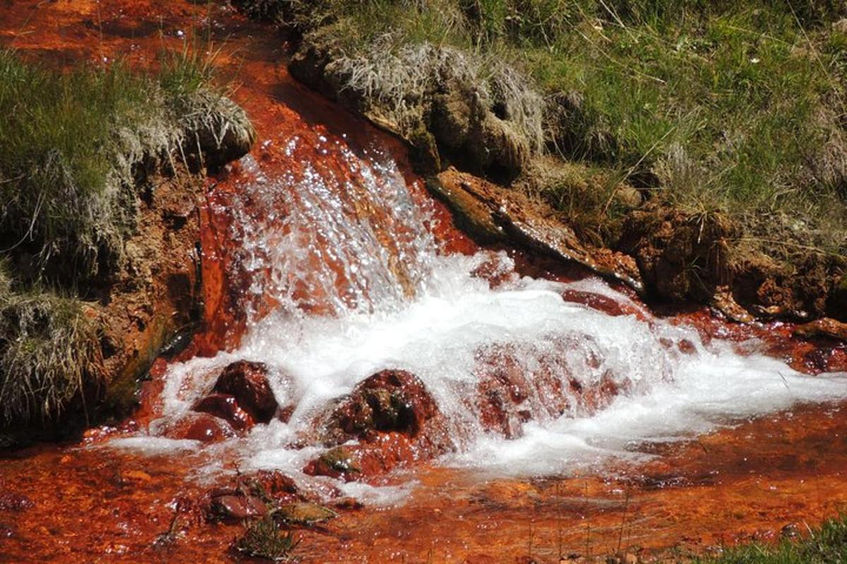 Un arroyo de agua con pintura roja en las rocas.