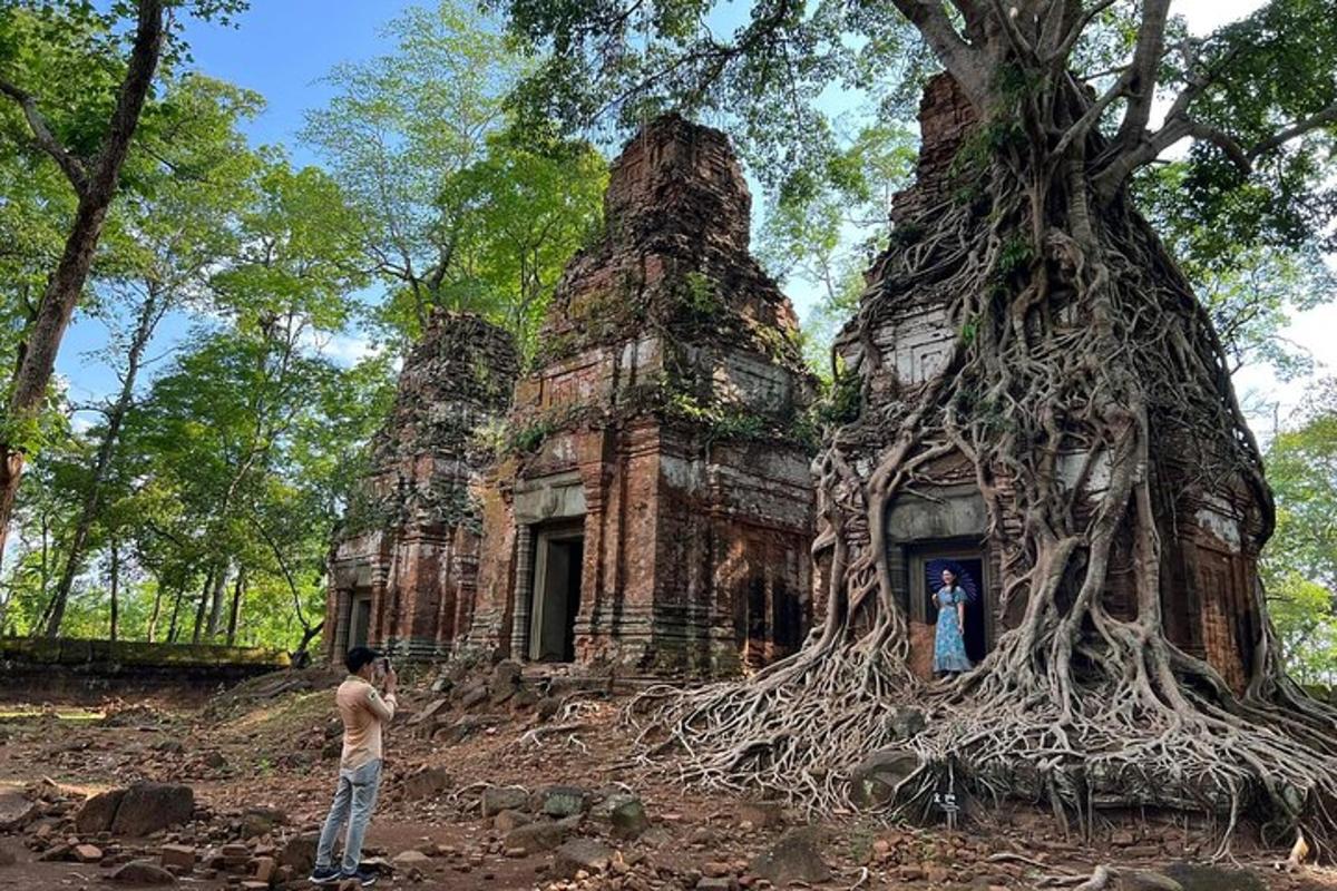 một người đàn ông đứng trước một tòa nhà cũ có rễ cây