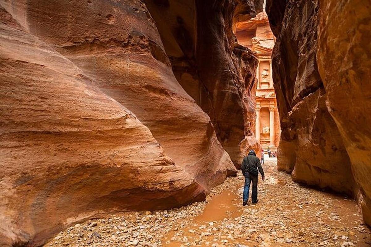 un uomo sta camminando attraverso un canyon a fessura