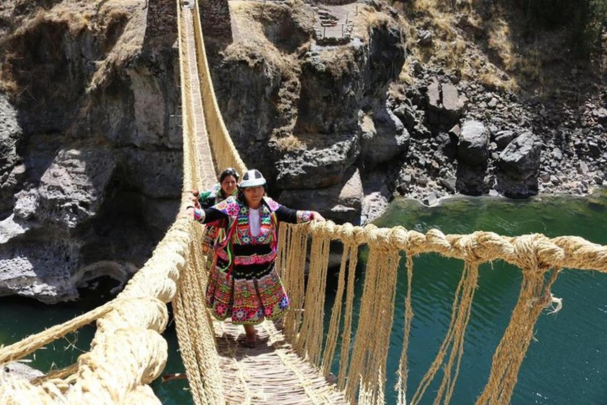 dues persones creuant un pont de corda sobre un riu