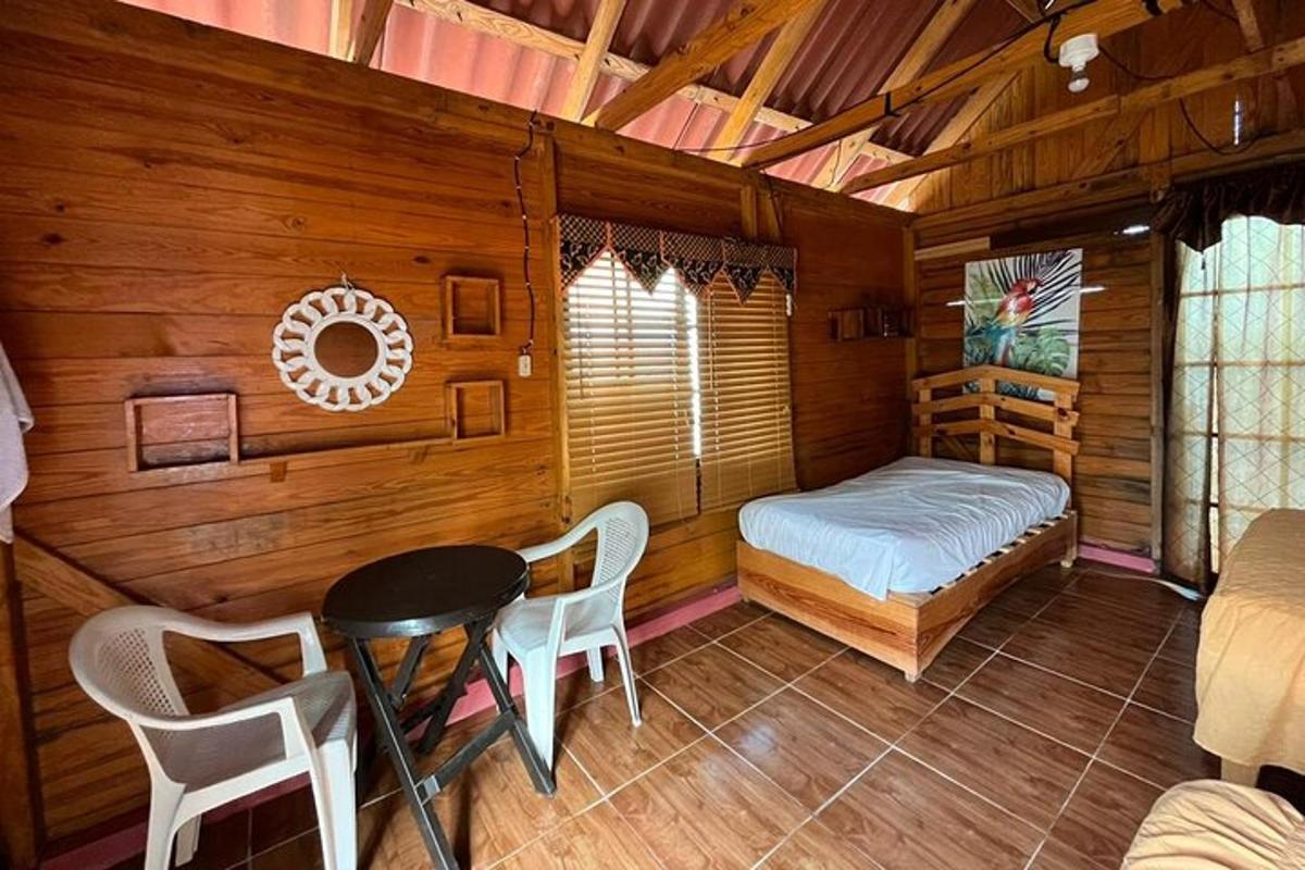 una stanza con un letto, un tavolo e delle sedie