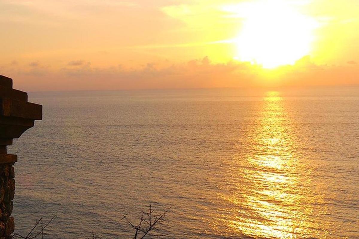 a sunset over the ocean with the sun in the sky