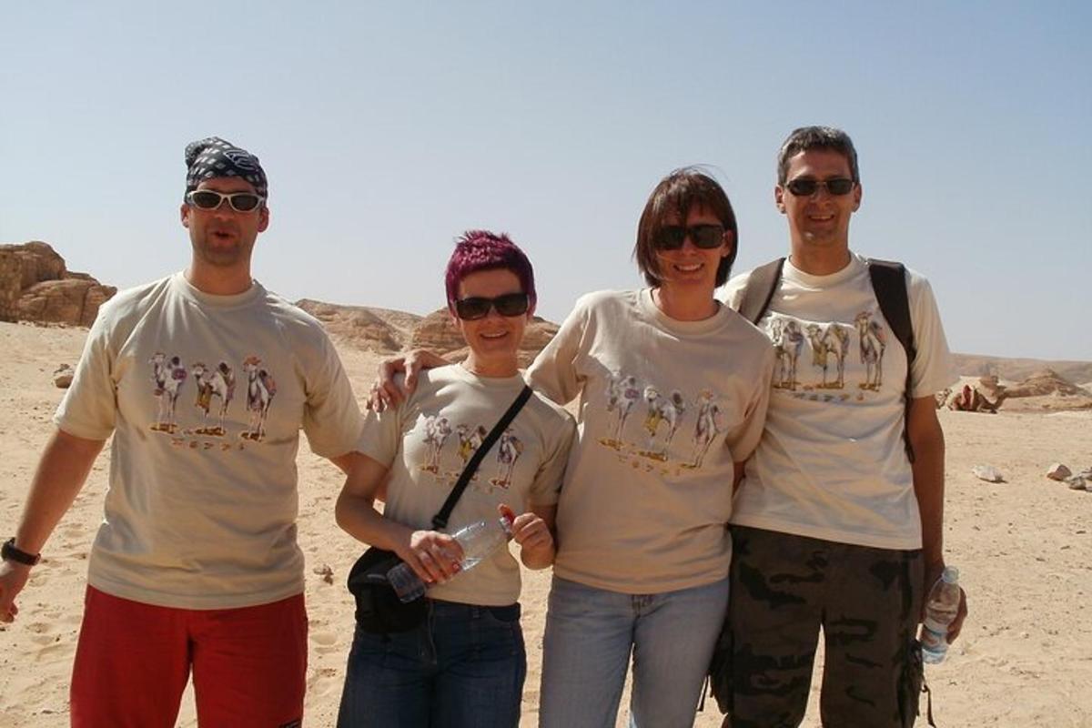 um grupo de quatro pessoas em pé no deserto