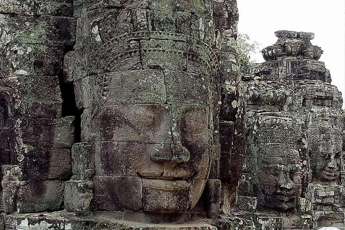 a stone statue of faces on the side of a building