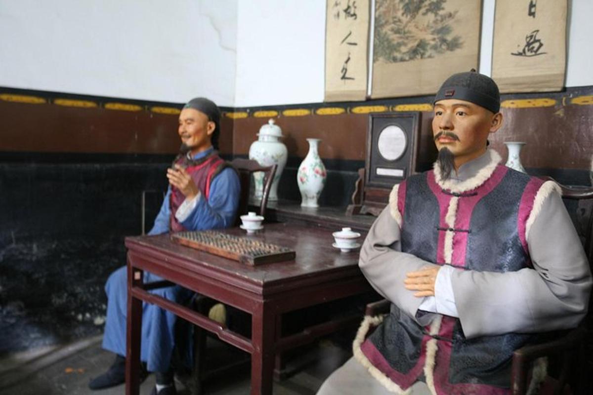 a statue of a man sitting at a table in a room