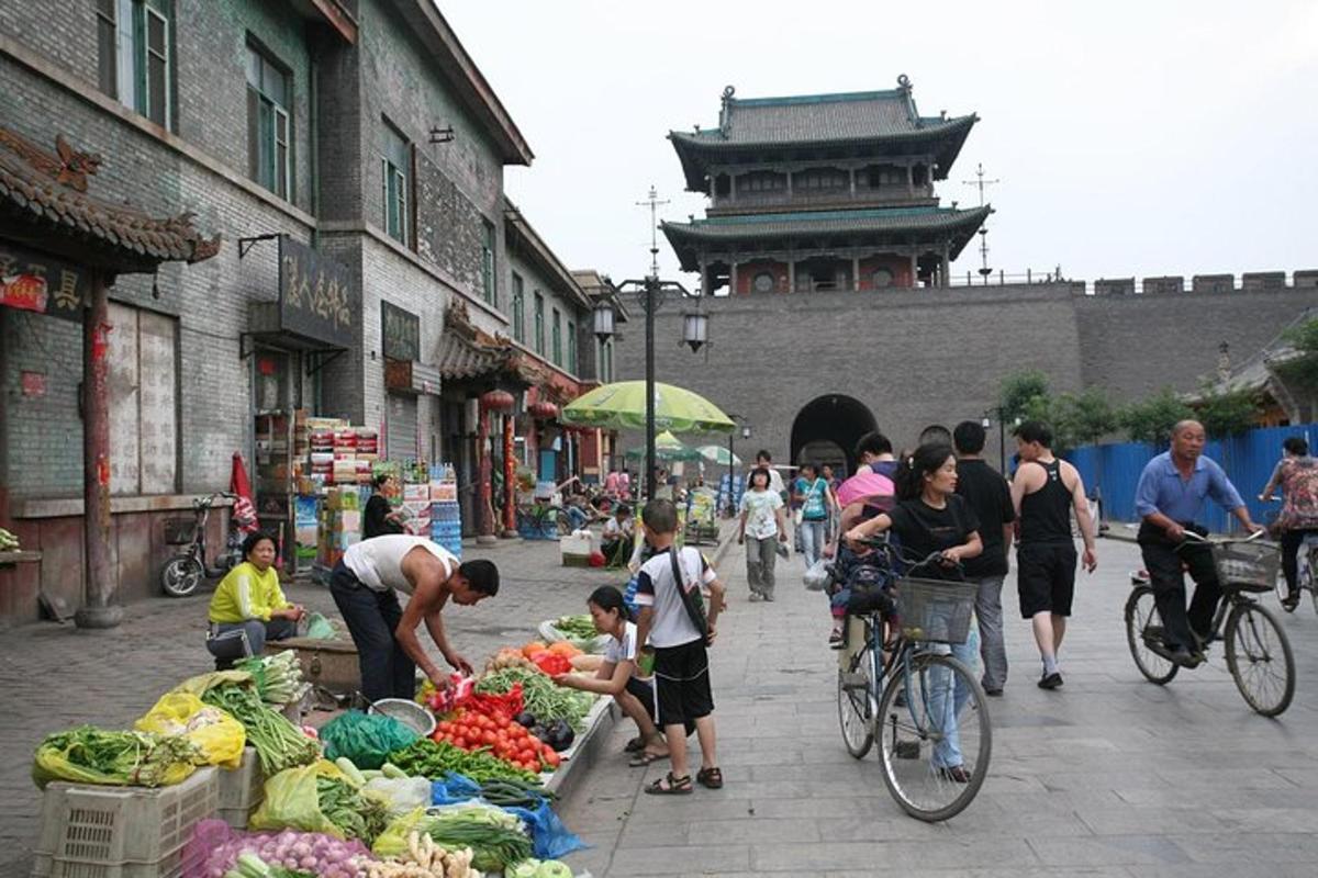 a group of people standing around a fruit and vegetable market