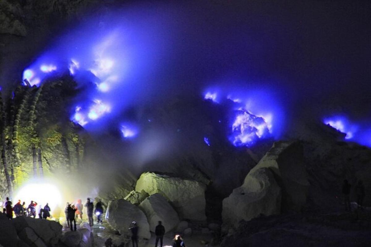 orang-orang berdiri di depan gua dengan lampu biru