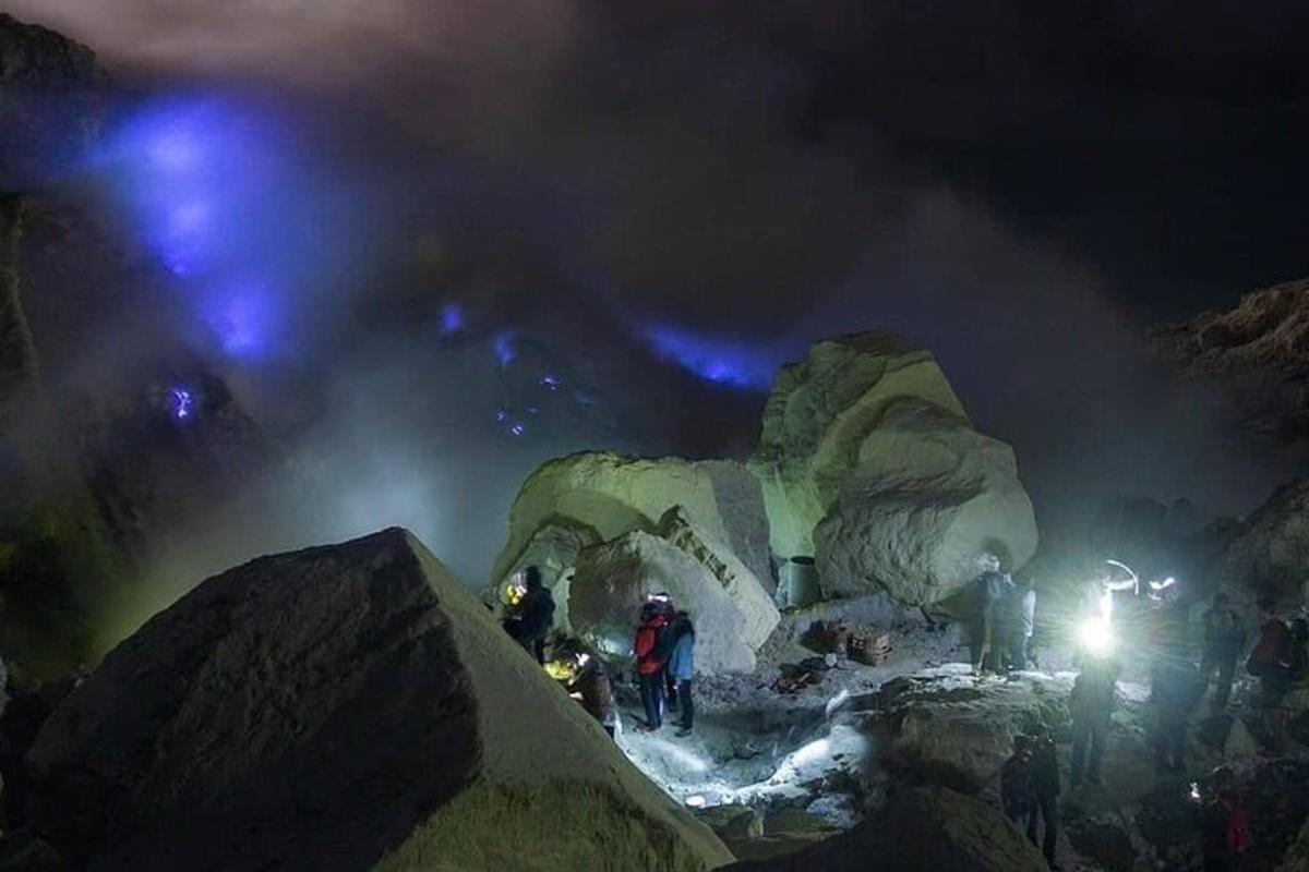 sekelompok orang yang berdiri di gunung pada malam hari