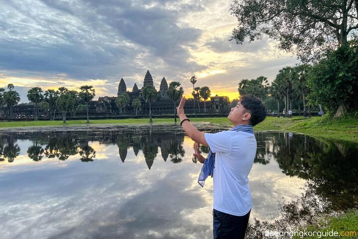isang lalaki na nakatayo sa harap ng isang lawa habang nasa ere ang kamay