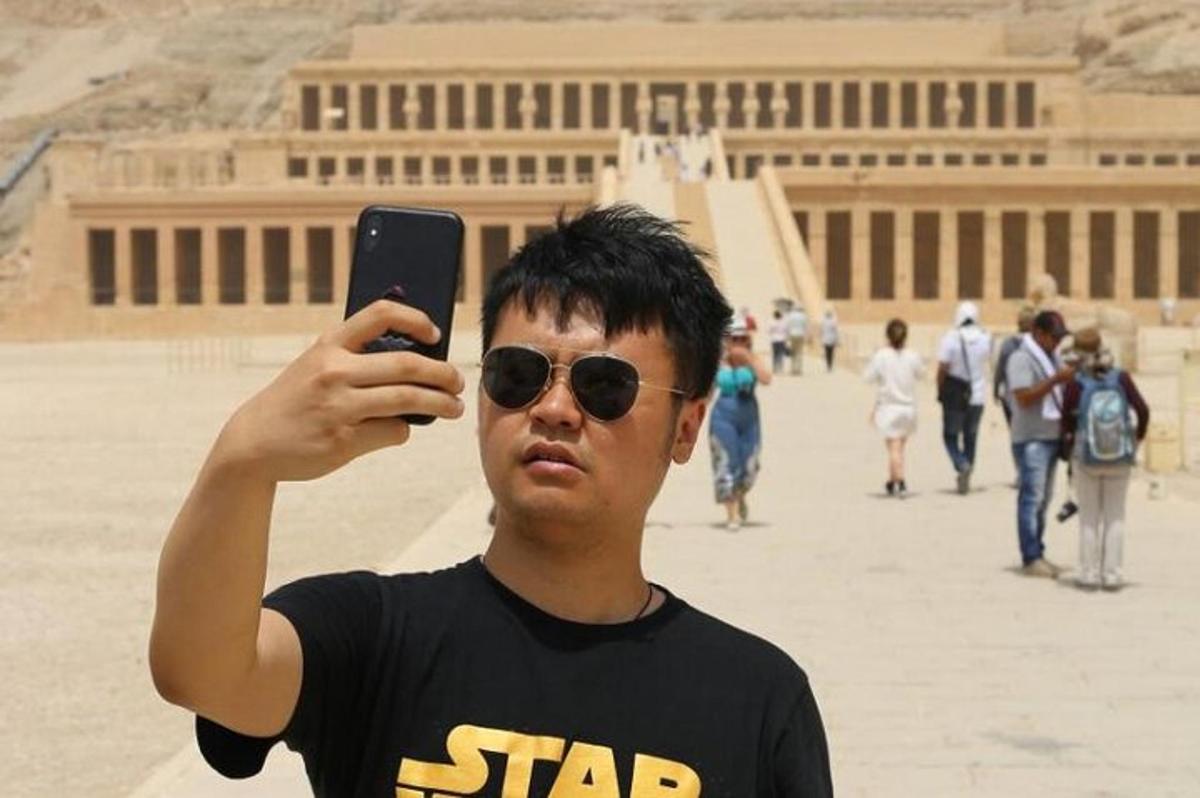 mees teeb hoone ees oma mobiiltelefoniga pilti