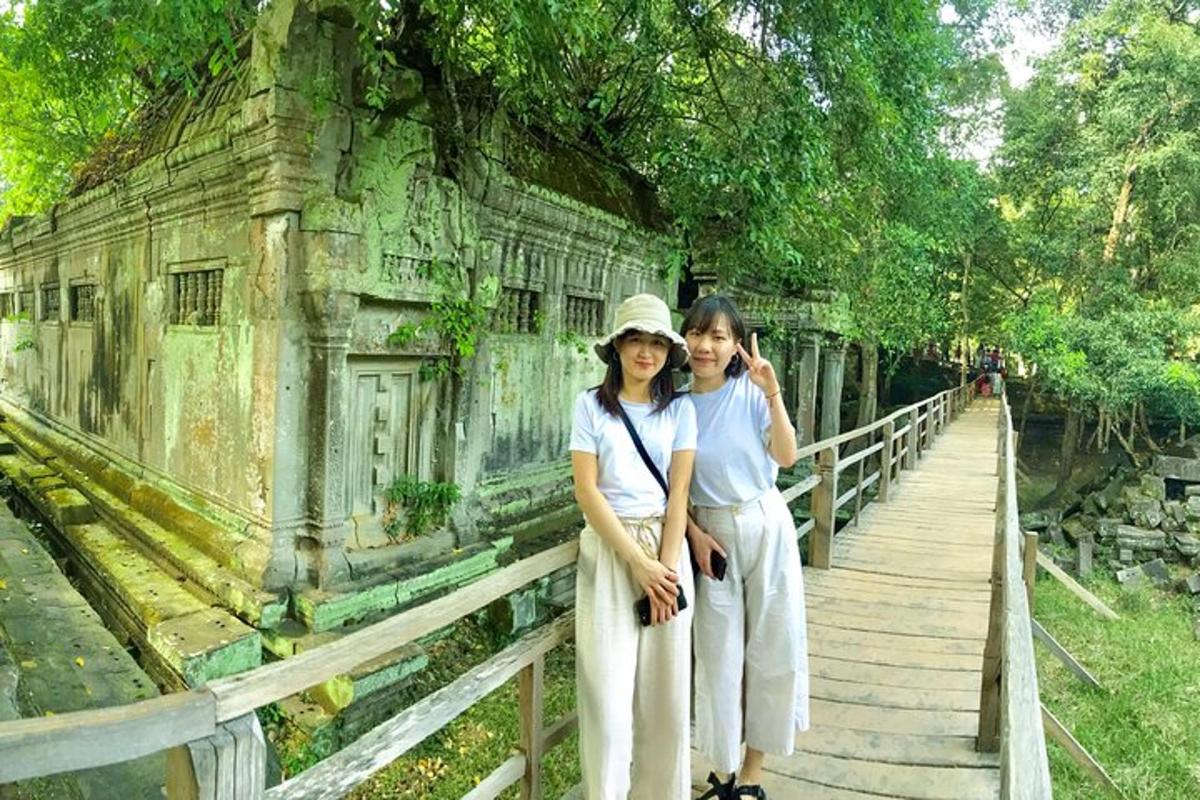 duas mulheres em pé em uma ponte em frente a um prédio