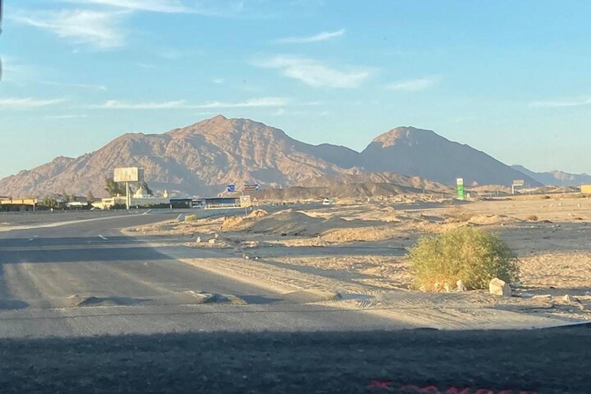 Una carretera vacía en medio de un desierto con montañas.