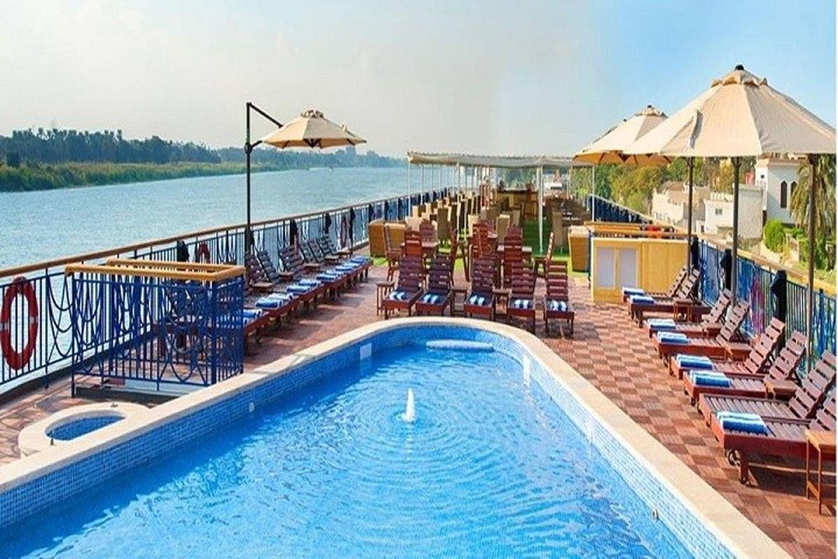 een zwembad met stoelen en parasols naast het water