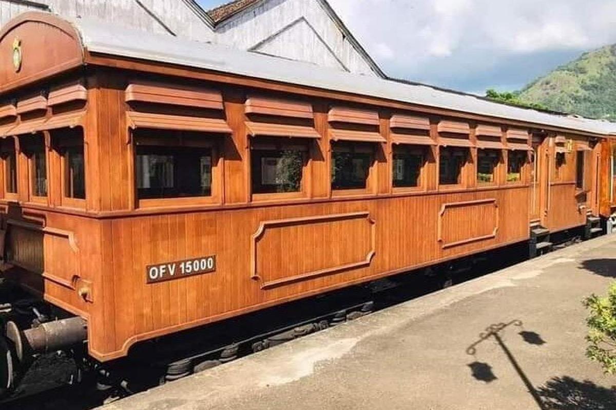 un vagon vechi de tren din lemn stând pe șine