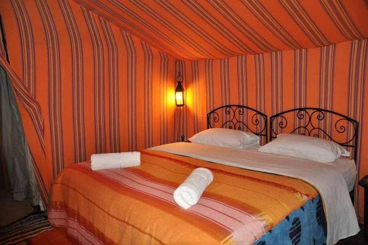 una camera da letto con un letto con due cuscini bianchi
