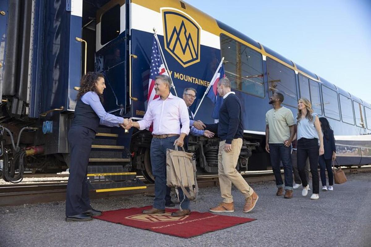 Un grupo de personas se dan la mano delante de un tren.