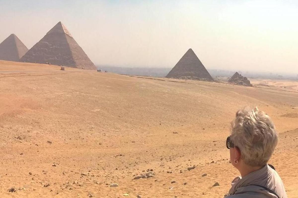 žena stojící před pyramidami v poušti