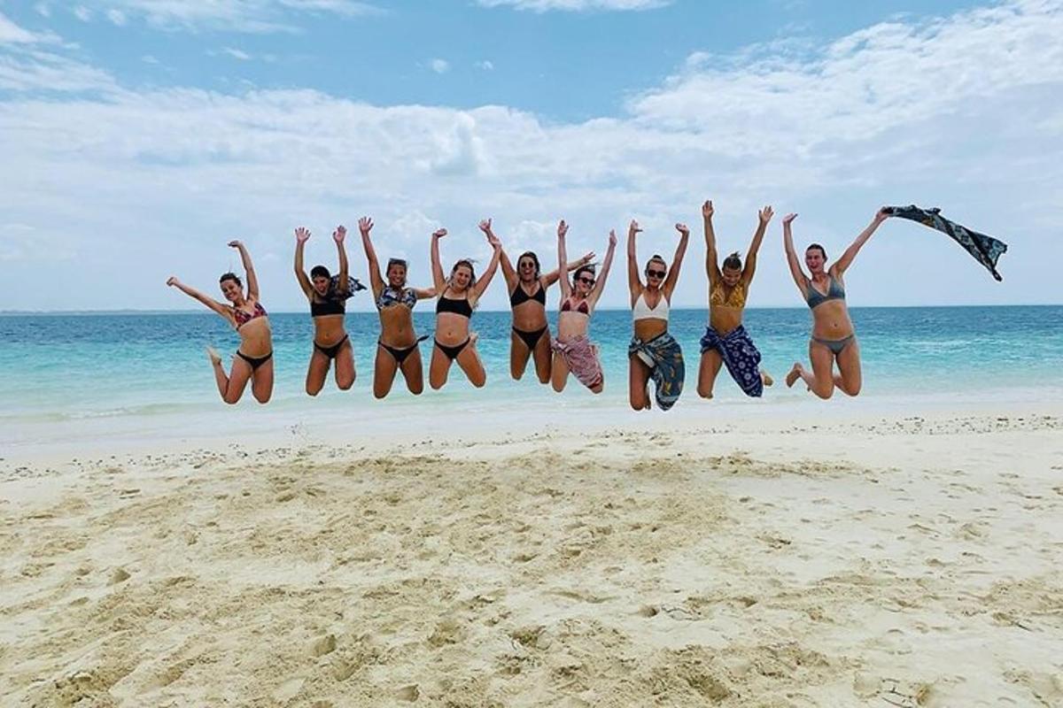a group of women jumping in the air on the beach