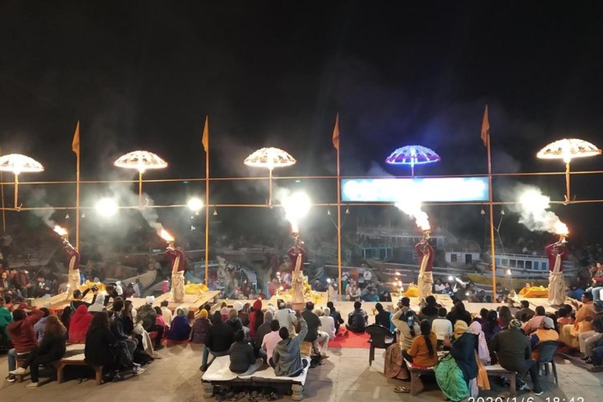 uma multidão de pessoas sentadas ao redor de um palco com guarda-chuvas