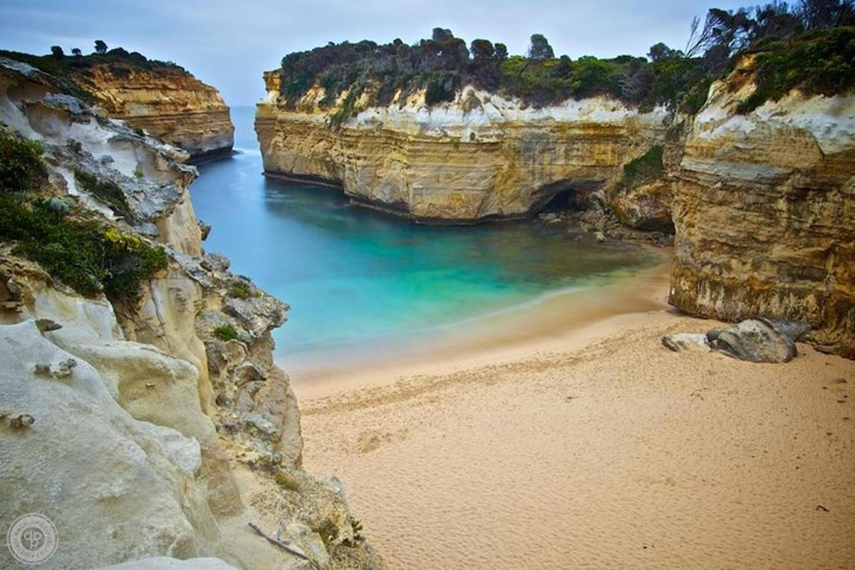 pemandangan pantai di antara dua tebing berbatu