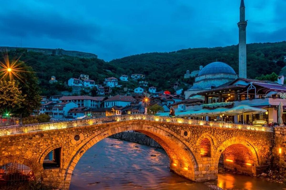 uma ponte sobre um rio com uma cidade ao fundo