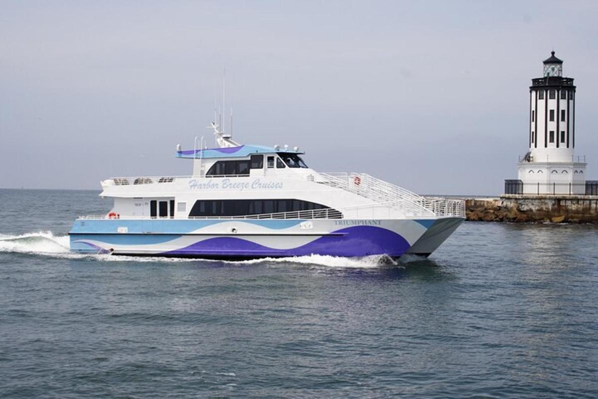 a large boat in the water near a lighthouse