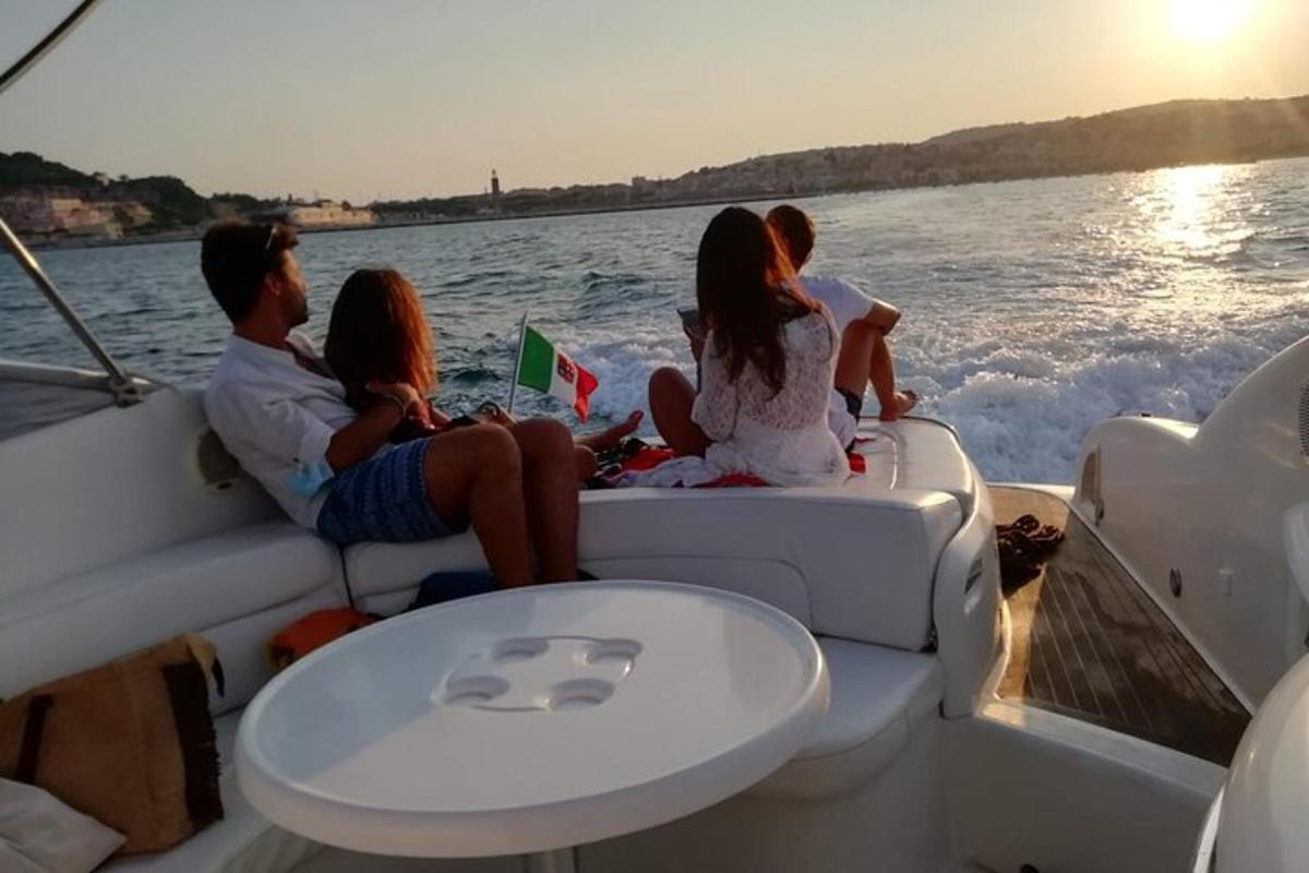 a group of people sitting on the back of a boat