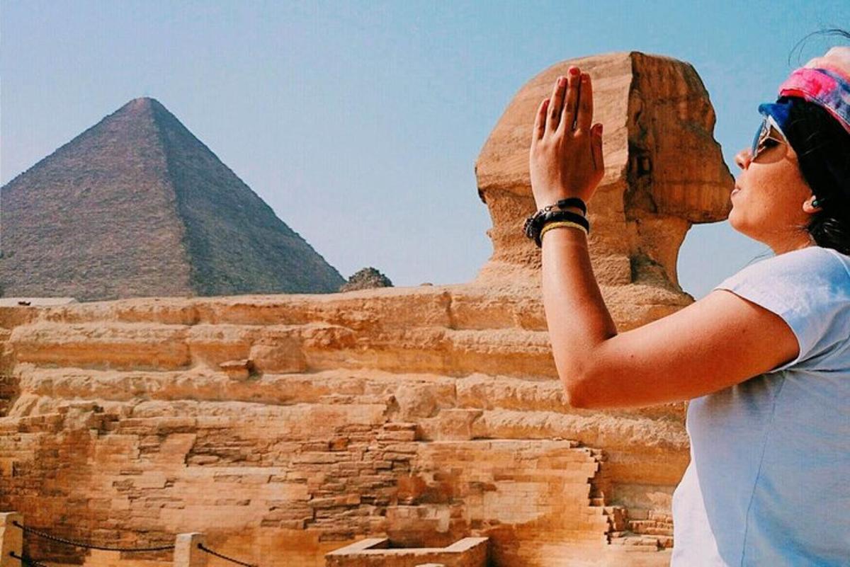 žena stojící před pyramidami