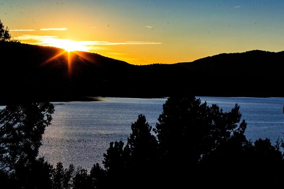 un tramonto su uno specchio d'acqua con alberi