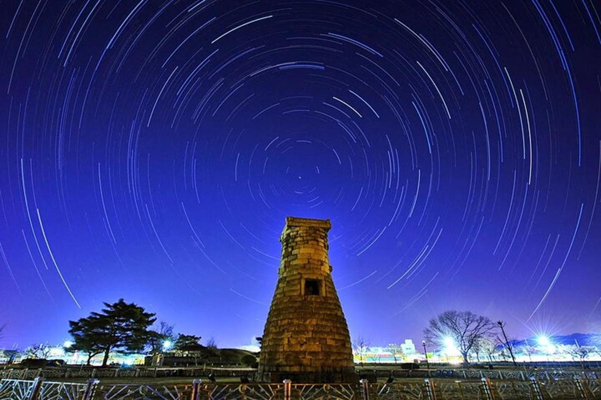 uma torre do relógio com rastros de estrelas no céu