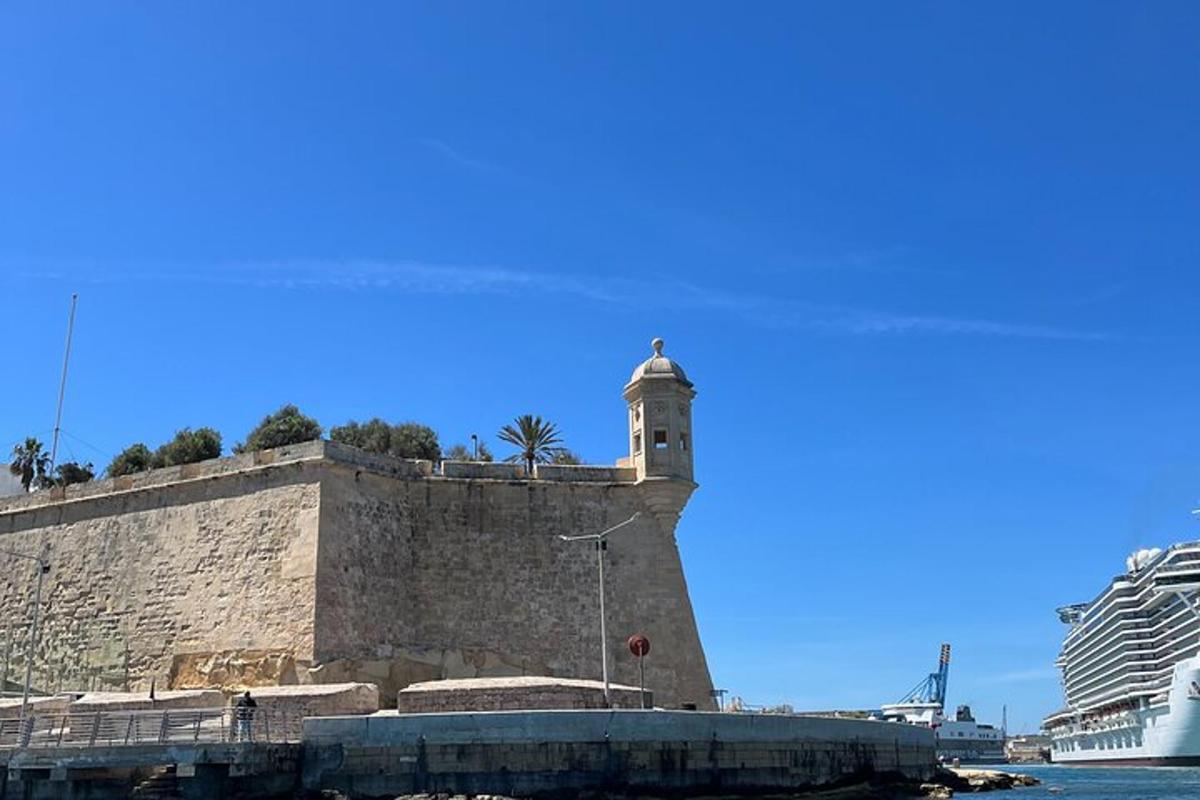 a stone wall with a tower next to the water
