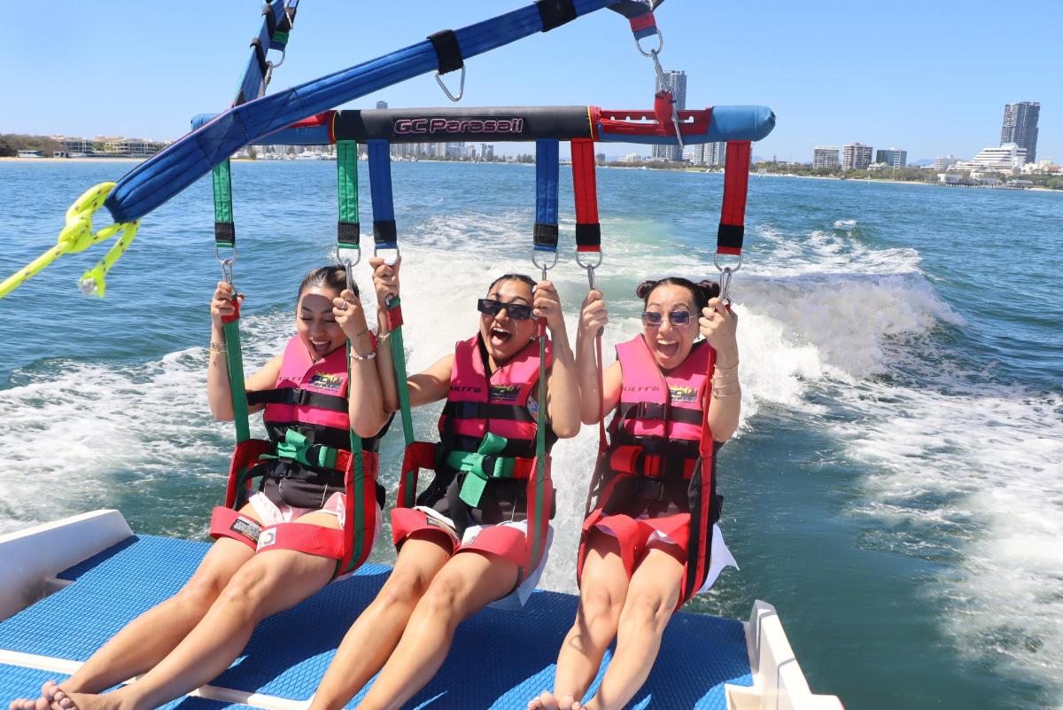 three girls are riding on a boat on the water
