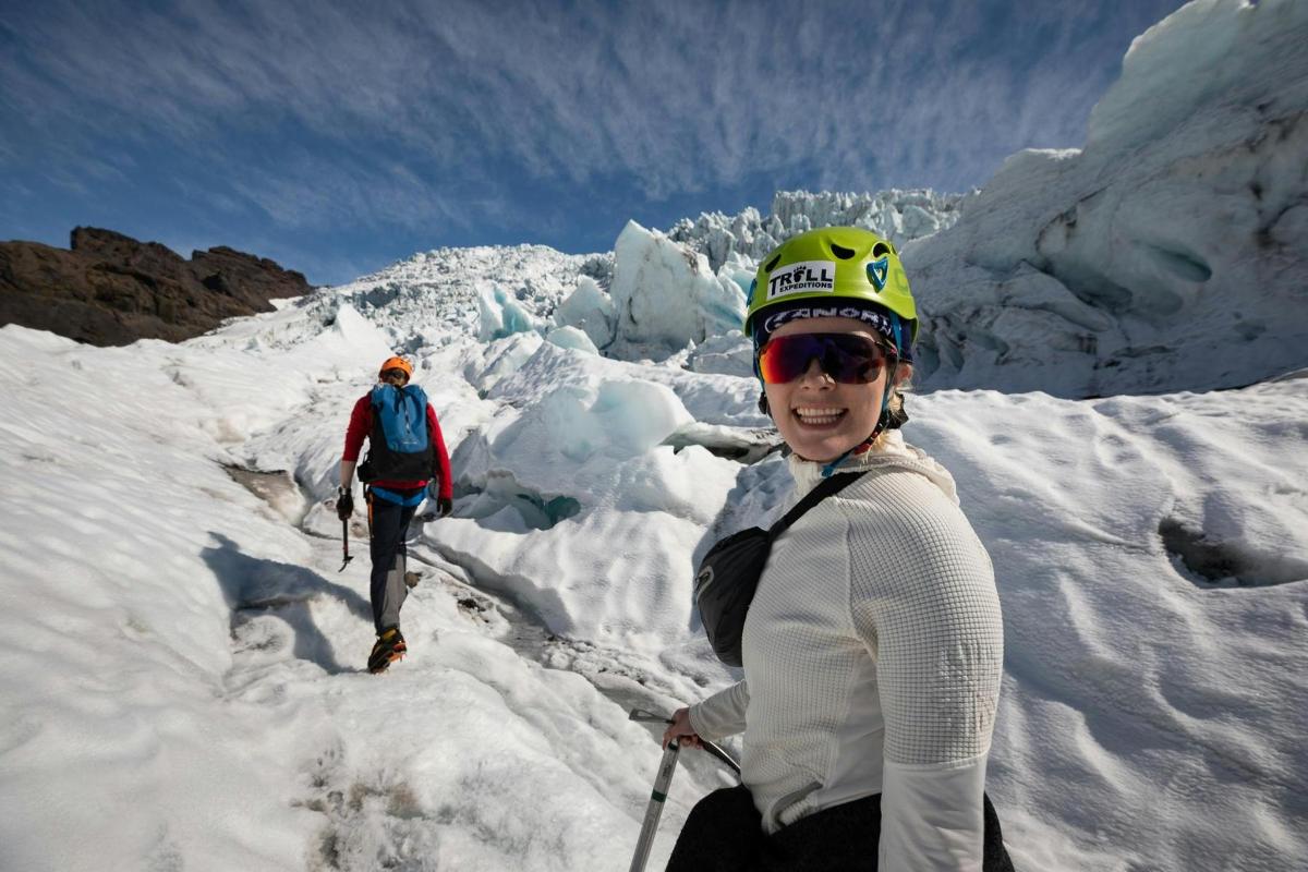 una donna in piedi sulla cima di una montagna innevata