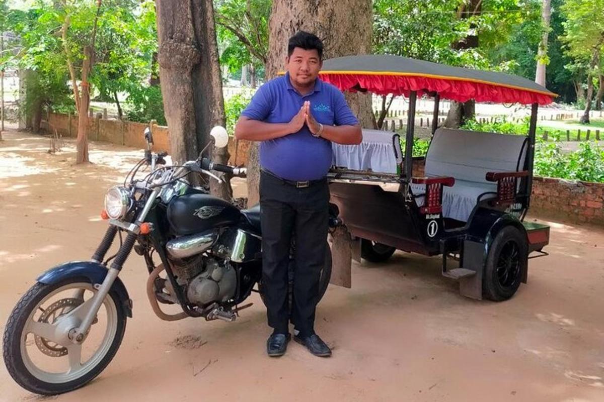 a man standing next to a motorcycle and a cart