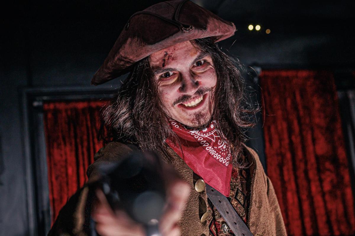 a man dressed as a witch taking a picture with a camera