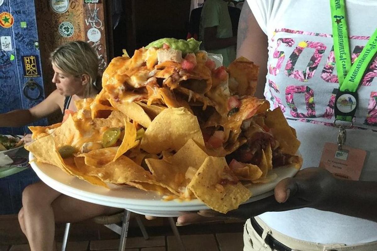 a person holding a plate of nachos