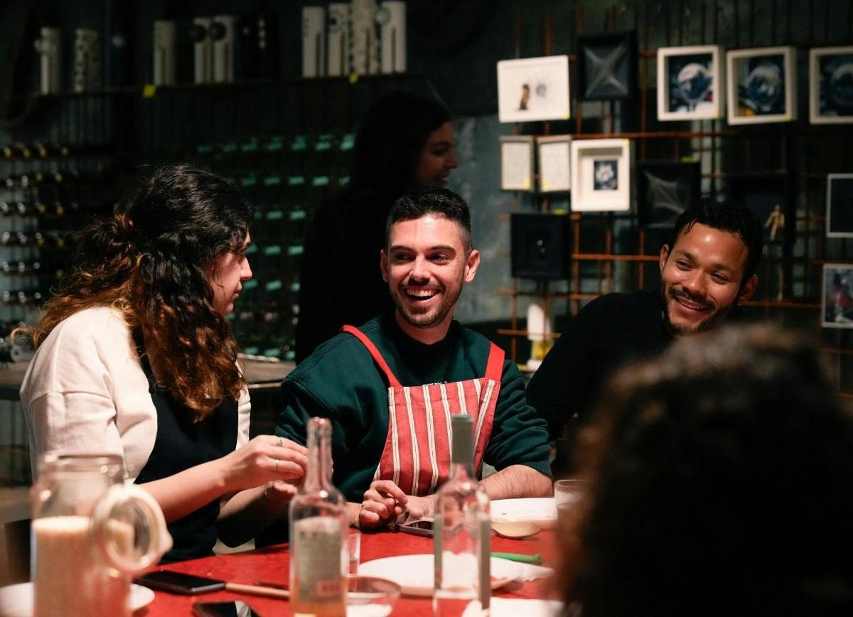 skupina lidí sedících kolem stolu v restauraci