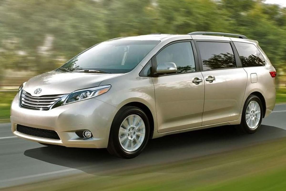 a silver minivan is driving down a road