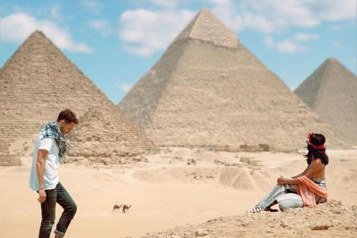 muž a žena stojící před pyramidami