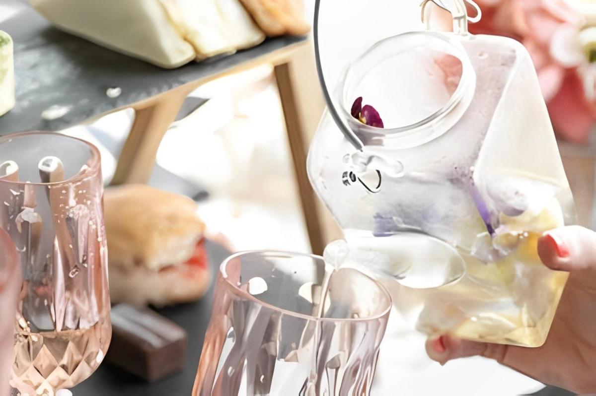 uma pessoa está despejando vinho em duas taças