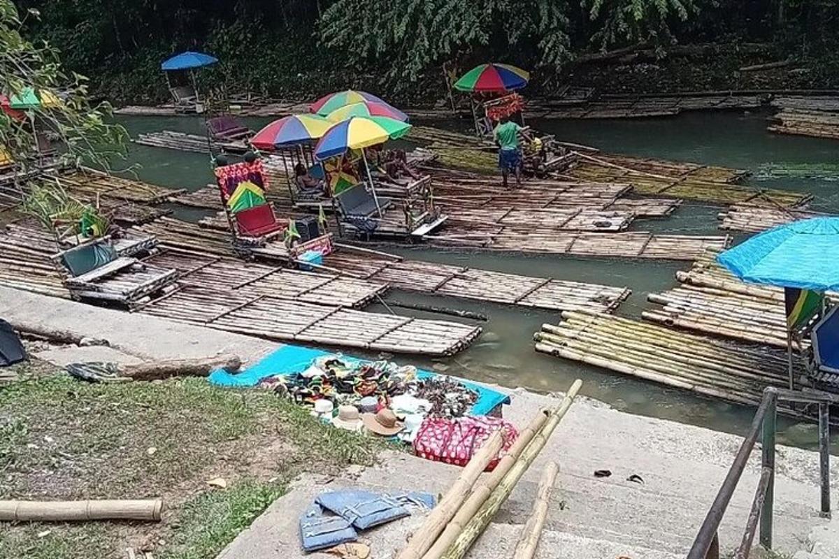 un gruppo di persone su una zattera in acqua con gli ombrelli