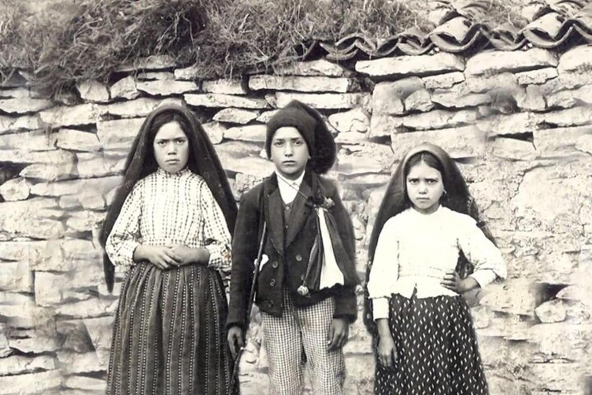 石壁の前に立つ3人の少女の白黒写真