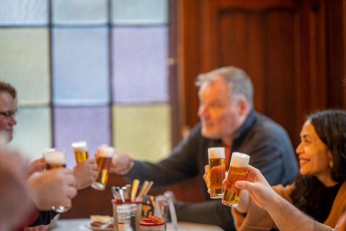 skupina lidí sedících kolem stolu a pijících pivo